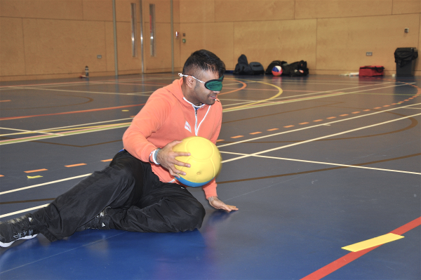 Participant playing goalball and wearing an eye mask
