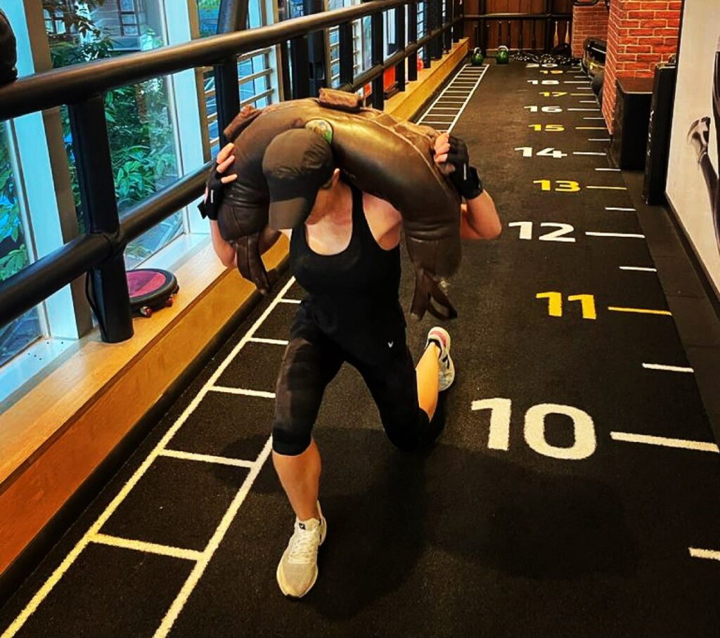 A woman carries a weight as she trains in a gym.